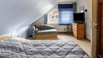 Une chambre à coucher avec un lit, un canapé, une télévision et une commode.