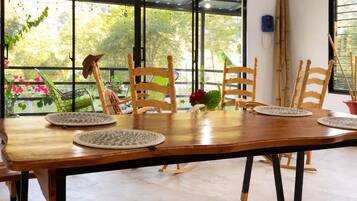 Un comedor con una mesa de madera larga, varias sillas y un banco.