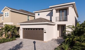 A modern two-story house with a garage, a balcony, and a well-maintained garden. - 5BR Encore Villa Movie-themed Game Room (Kissimmee)