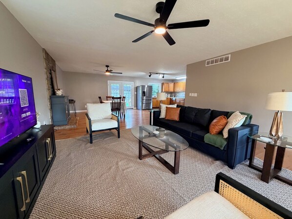 A modern living room with a television, seating area, and a ceiling fan. - Newly Renovated 2BR Retreat – Minutes from CVG & Cincinnati (Petersburg)