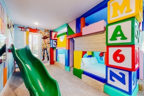 A children's playroom with a slide, colorful alphabet blocks, and a bed. - 5BR Bear's Den Estate Arcade, Pool & Game Room (Kissimmee)