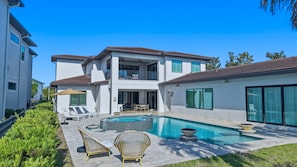 A modern two-story house with a swimming pool, outdoor seating, and a well-maintained garden. - 5BR Bear's Den Estate Arcade, Pool & Game Room (Kissimmee)