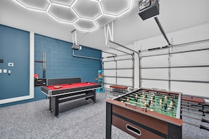 A recreational room with a pool table, foosball table, and ping pong table. - 5BR Encore Sleeps 12 w/ Pool, Spa & Game Tables (Kissimmee)