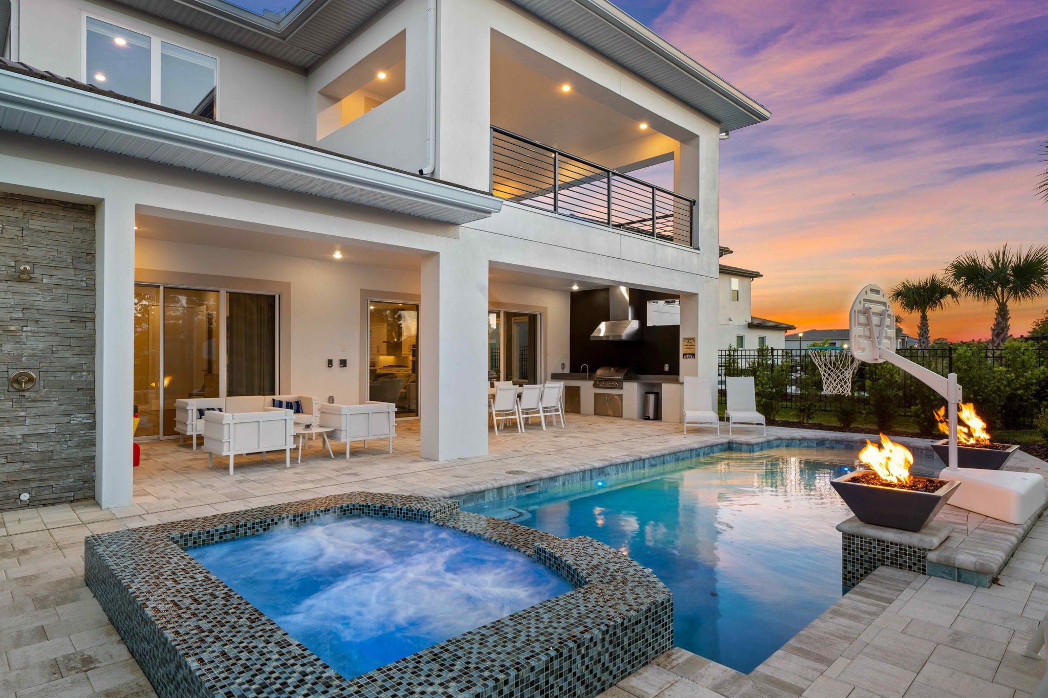 A modern house with a swimming pool, outdoor seating, and a barbecue area.