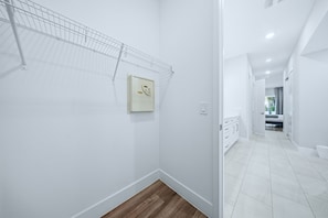 A hallway with white walls, a metal rack, and a control panel. - 5BR Bear's Den Theater, Pool & Spa (Kissimmee)
