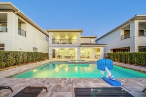 A modern two-story house with a swimming pool, outdoor seating, and a basketball hoop. - 5BR Bear's Den Estate Private Pool & Game Room (Kissimmee)