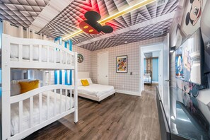 A children's room with bunk beds, a single bed, and a wall with cartoon character posters. - 5BR Bear's Den Estate Private Pool & Game Room (Kissimmee)