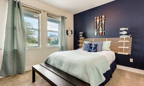 A bedroom with a bed, a bench, a window with curtains, and a wall with decorative items. - 9BR Encore Villa Custom Design & Game Room (Kissimmee)