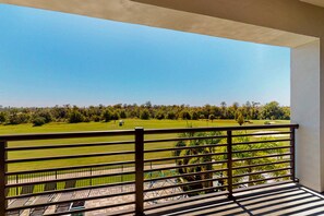 Ein Balkon mit Blick auf einen Golfplatz.