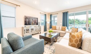 Ein modernes Wohnzimmer mit einer Sofagarnitur, einem Couchtisch und einem Fernseher.