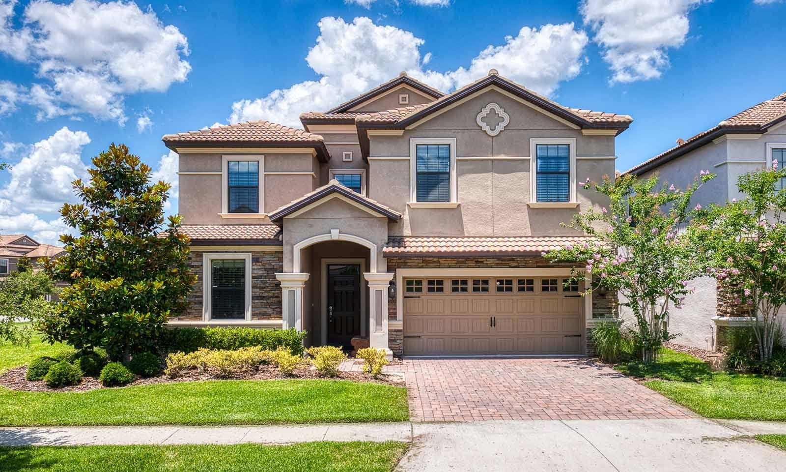 A two-story house with a front entrance, a garage, and a well-maintained lawn.