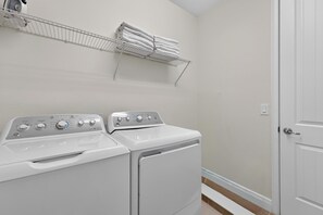 A laundry room with two stacked washing machines and a drying rack above them. - 6BR Encore w/ Under-the-sea Kids' Room & Pool (Kissimmee)