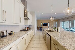 Eine moderne Küche mit weißen Schränken, Granit Arbeitsplatten und Edelstahlgeräten.