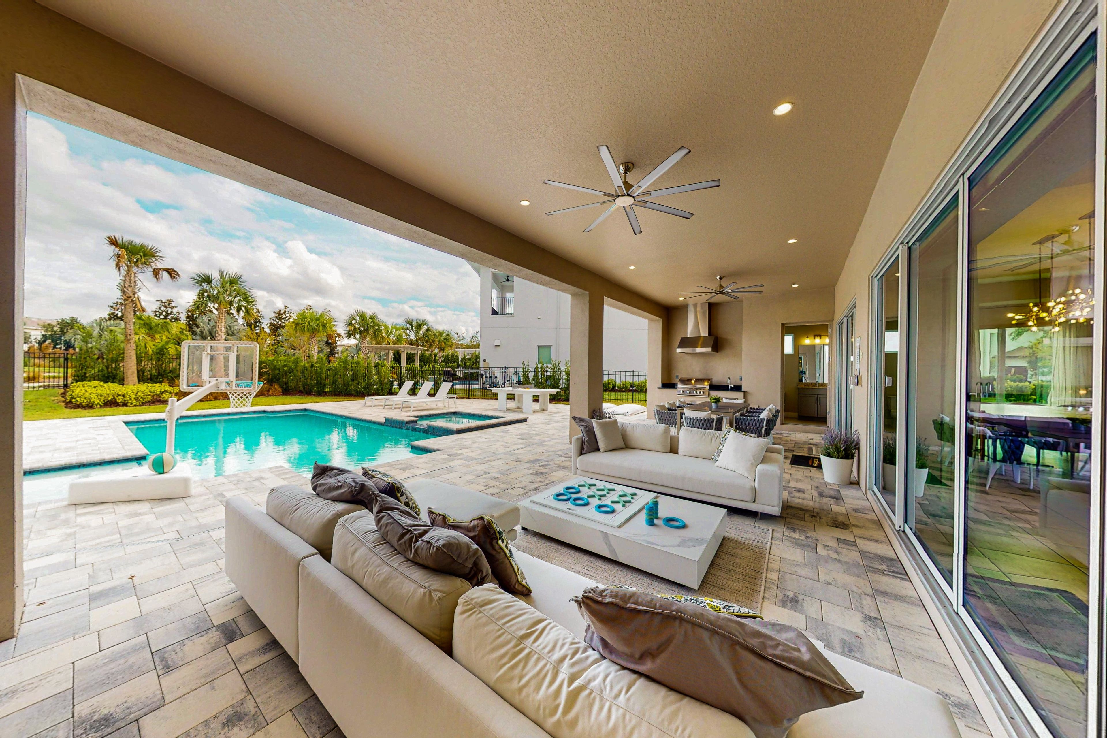 A modern outdoor living area with a pool, seating, and a view of the outdoors.