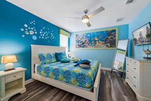 A bedroom with a bed, a ceiling fan, a wall mural, a dresser, and a television. - 8BR Championsgate Villa Theater, Pool & Games (Davenport)