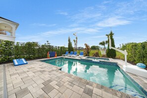 A swimming pool with lounge chairs and a basketball court. - Bohemian Chic Oasis With Themed Bedrooms at Reunion (Kissimmee)