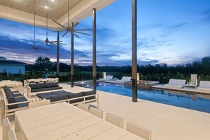 Ein Poolbereich auf dem Dach mit Liegemöbeln und Deckenventilatoren.