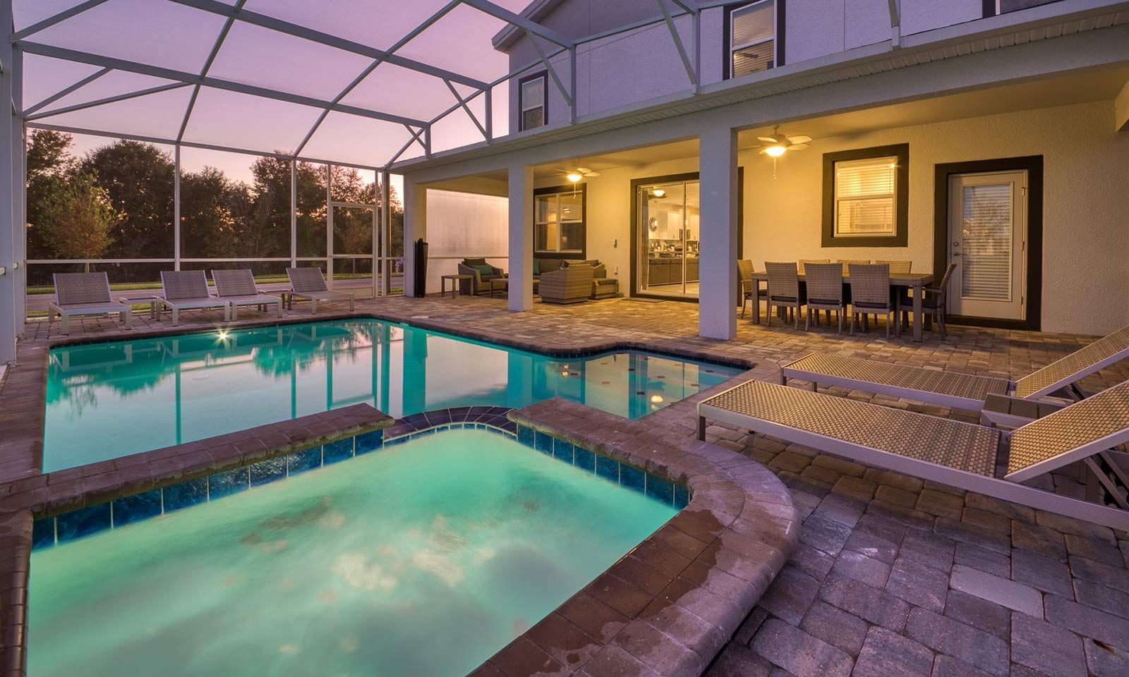 A pool area with lounge chairs and a covered patio.