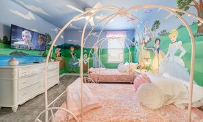 A bedroom with a canopy bed, a dresser, and a mural of animated characters. - 8BR Championsgate Theater, Arcade & Pool (Davenport)