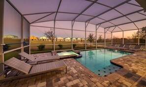 A covered outdoor swimming pool with lounge chairs and a hot tub. - 8BR Championsgate Theater, Arcade & Pool (Davenport)