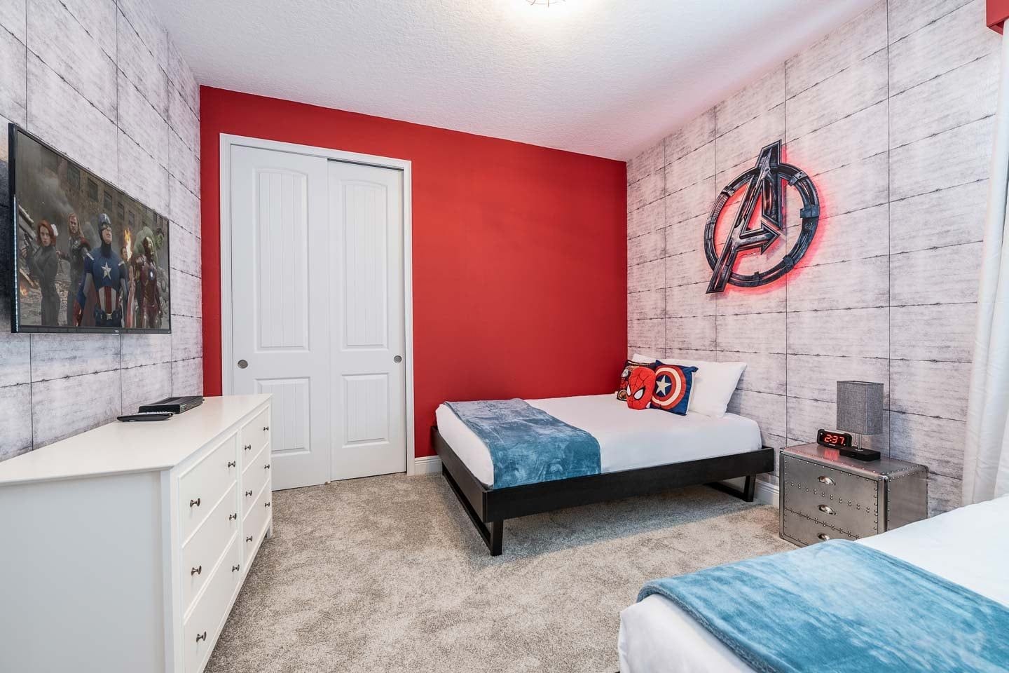 Ein Schlafzimmer mit einem Bett, einer Kommode, einem Nachttisch, einer Uhr und einer Wand mit einem Rundmuster.