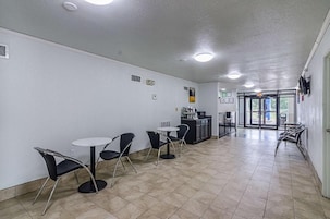 Un espacio interior moderno y limpio con una recepción, un mostrador y zonas de estar.