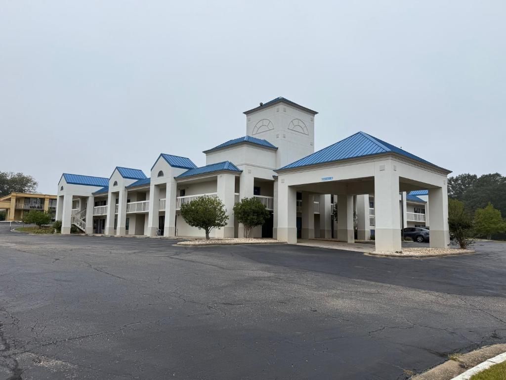 A hotel with a central tower, multiple wings, and a parking lot.