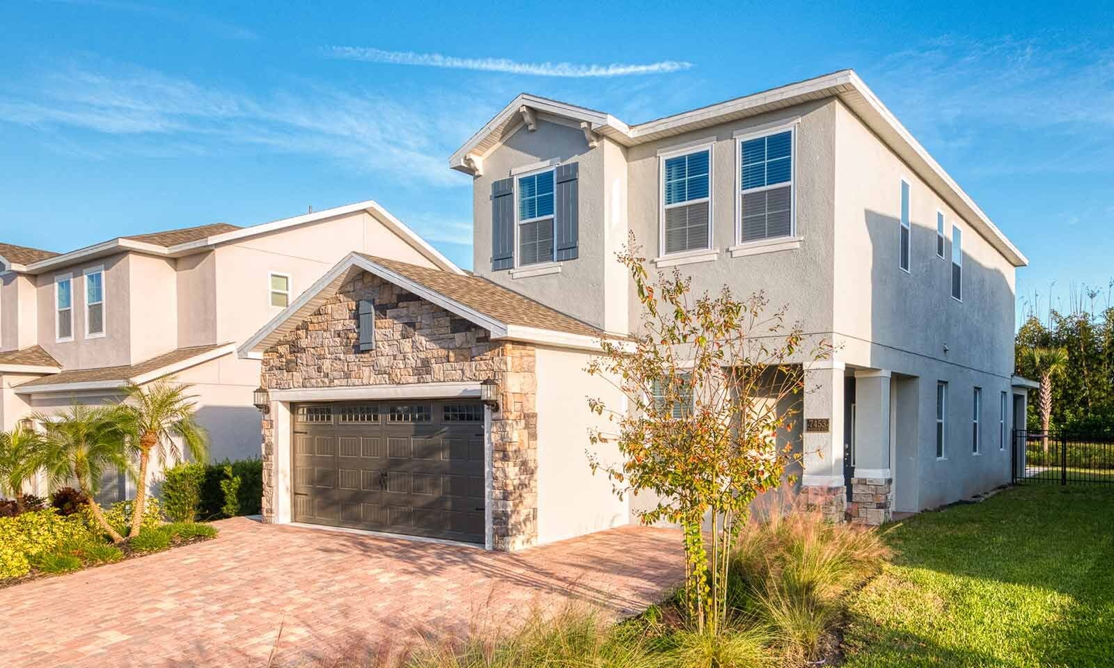 A modern two-story house with a stone facade and a garage.