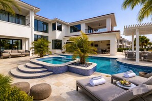 A modern pool area with a hot tub, lounge chairs, and outdoor furniture. - 6BR Reunion Mansion Circus Room & Karaoke (Kissimmee)