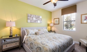 A bedroom with a bed, nightstands, a ceiling fan, and a window with blinds. - 8BR Championsgate Villa Pool, Spa & Theater (Davenport)