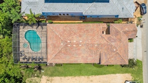 An aerial view of a property with a swimming pool, a covered patio area, and a parking lot. - Deluxe Villa With Guest Suite at Reunion (Kissimmee)