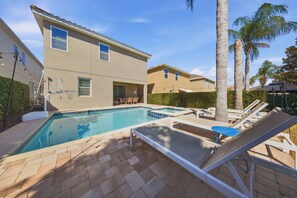 A residential swimming pool with lounge chairs and a patio area. - 8BR pet Friendly Home With Private Pool at Encore (Kissimmee)