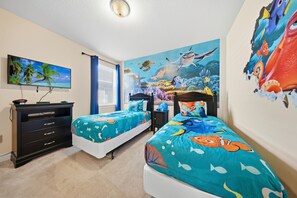 A bedroom with two beds, a TV, a dresser, and a mural of an underwater scene. - 8BR pet Friendly Home With Private Pool at Encore (Kissimmee)