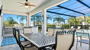 Un patio exterior con una parrilla, asientos y una zona de piscina.