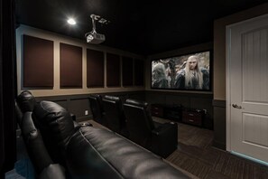 A home theater with a large screen, leather seating, and a projector. - Encore 8BR Villa, Home Theater, Near Disney (Kissimmee)