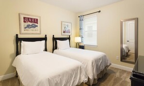 A hotel room with two single beds, a nightstand with a lamp, a framed picture on the wall, and a window with blinds. - 10br Unique Encore Villa Water Park & Pool (Kissimmee)