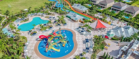Vista aérea de un complejo turístico con parque acuático, piscina y zona residencial.