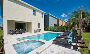 A modern residential building with a swimming pool, outdoor seating, and a well-maintained garden. - 8BR Encore Villa With Galactic Game Room (Kissimmee)