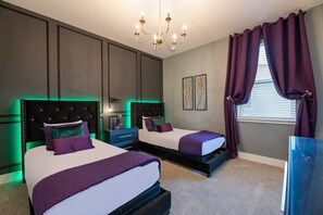 A bedroom with two beds, a chandelier, and a window with curtains. - Colorful 10br at Encore, 10 Min to Disney (Kissimmee)