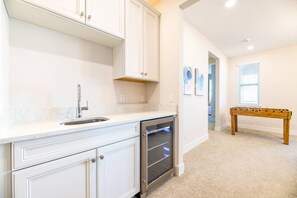 A kitchen with white cabinetry, a stainless steel sink, and a built-in oven. - Colorful 10br at Encore, 10 Min to Disney (Kissimmee)
