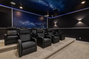 A home theater room with a starry ceiling, black leather recliners, and carpeted flooring. - Colorful 10br at Encore, 10 Min to Disney (Kissimmee)