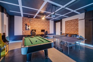A billiards room with a pool table, two ping pong tables, and a projector mounted on the ceiling. - Colorful 10br at Encore, 10 Min to Disney (Kissimmee)