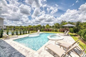 A rectangular swimming pool with a hot tub, surrounded by lounge chairs and a fence. - Encore Estate, 6br, 10 Min to Disney (Kissimmee)