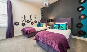 A bedroom with two beds, a wall decorated with vinyl records, a disco ball, and a teal accent wall. - Colorful Villa With Game Room in Encore (Kissimmee)