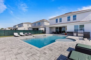 A residential property with a swimming pool, outdoor seating, and a barbecue area. - Colorful Villa With Game Room in Encore (Kissimmee)