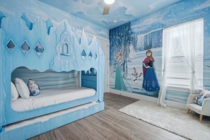 Ein Kinderzimmer mit Bett, Wandgemälde und einem Vorhangfenster.