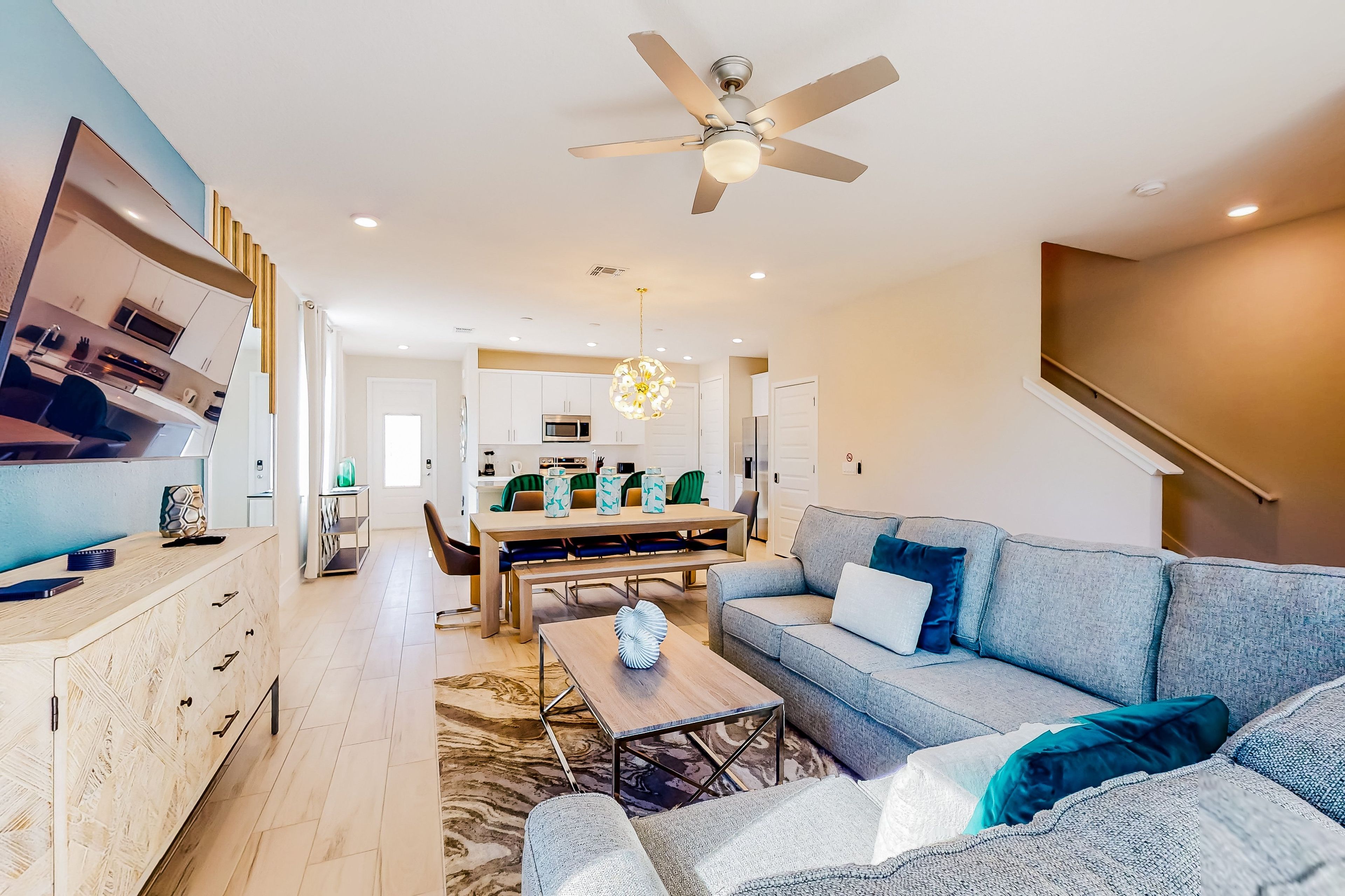 A modern living room with a sofa, coffee table, and a TV on a stand.