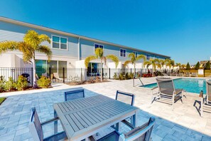 Un hôtel doté d’une piscine, d’un espace extérieur aménagé et de palmiers.