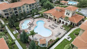 A residential area with a swimming pool, lounge chairs, and a covered seating area. - Bella Piazza 3BR Retreat Near Orlando Attractions (Davenport)