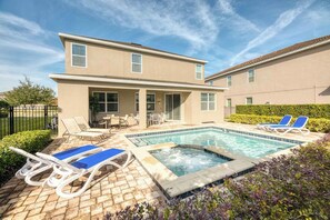 A two-story house with a swimming pool, outdoor seating, and a patio area. - Encore 6BR Home, Pool & Game Room, Near Disney (Kissimmee)